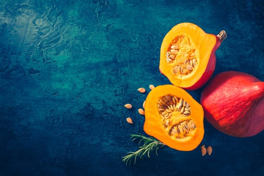 Organic pumpkin with seeds ready for cooking on blue background with copy space