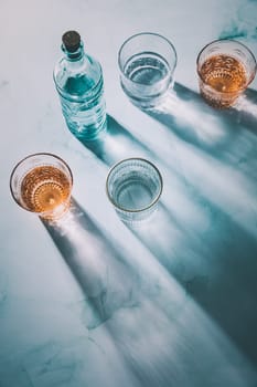 Water in vintage glasses with bottle