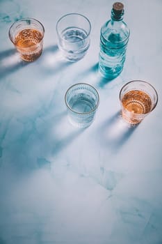 Water in vintage glasses with bottle