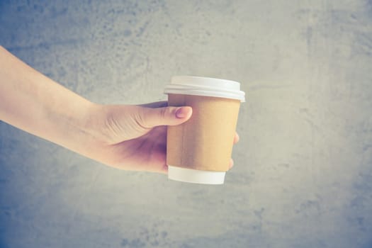 Hand holding disposable coffee cup