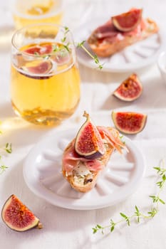 Small canape snack, crostini with ham, fig and apple wine, Italian antipasti
