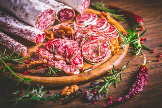 Charcuterie - Assortment of air-dried salami and sausage on wooden cutting board with spices