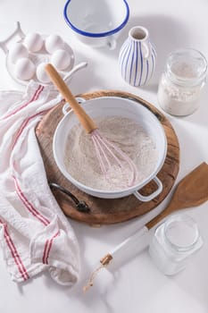 Flour and egg with baking ingredients and kitchen utensils