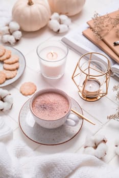 Autumn and winter still life with hot chocolate and cocoa, cookies, candles in white