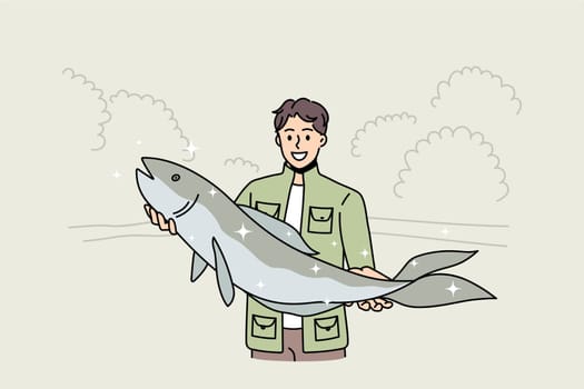 Smiling young fisherman hold big fish proud of good haul or hunt. Happy man in green costume satisfied with successful fishing. Hobby, fishery concept. Flat vector illustration, cartoon character.