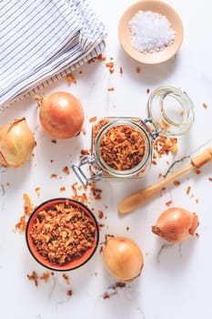 Making homemade fried onions with ingredients on white kitchen table