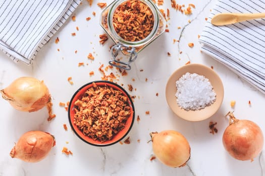 Making homemade fried onions with ingredients on white kitchen table