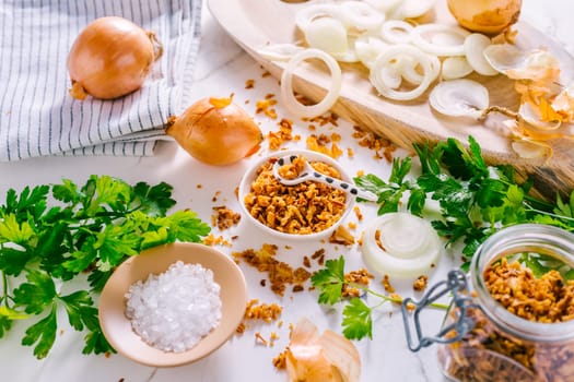 Making homemade fried onions with ingredients on white kitchen table