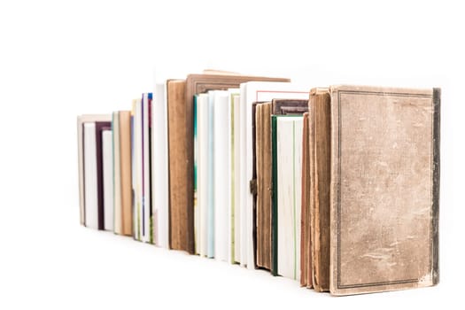 Assortment of new and old books in a row isolated on white background.