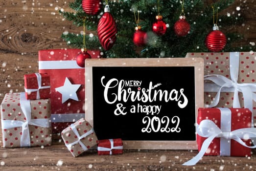 Blackboard With English Text Merry Christmas And A Happy 2022. Christmas Tree With Decoration Like Snowflakes, Gifts And Presents,Balls