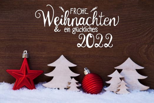 German Calligraphy Frohe Weihnachten Und Ein Glueckliches 2022 Means Merry Christmas And Happy 2022. Christmas Decoration Like Tree And Ball On Snow WIth Wooden Background
