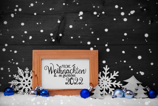 German Calligraphy Frohe Weihnachten Und Ein Glueckliches 2022 Mean Merry Christmas And Happy 2022. Blue Christmas Ornament Like Tree, Snowflake And Ball. Wooden Background With Snow And Snowflakes