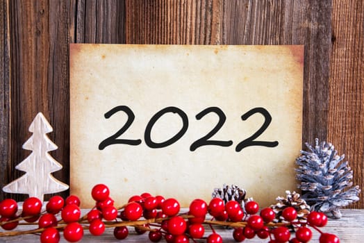 Paper With Text 2022 For Happy New Year Greetings. Christmas Decoration And Wooden Background
