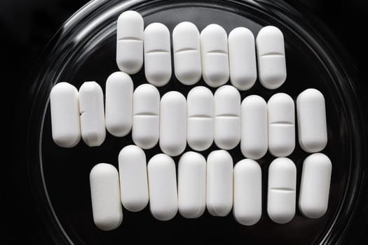 Many pills in glass saucer. Healthcare concept. Flat lay.