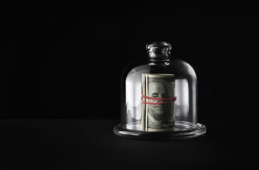 Pack of dollars under glass cap. Money under the glass cover. Copy space for text.