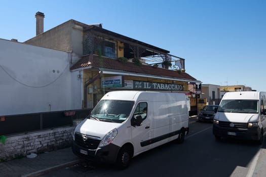 Civitavecchia. Italy - January 26, 2025: Tobacco shop in Civitavecchia with self-service kiosk, continuous opening hours and visible signage A person enters the establishment and there is a car parked
