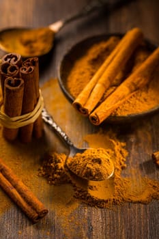 Assortment of cinnamon and gingerbread seasoning for cooking and baking on brown wooden background