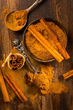 Assortment of cinnamon and gingerbread seasoning for cooking and baking on brown wooden background
