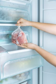 Taking frozen meat from the modern no-frost freezer
