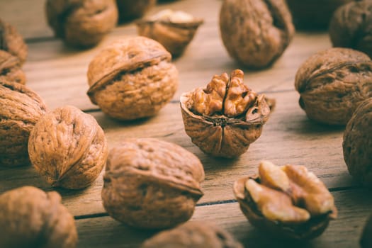 Organic walnuts with small nutcraker as baking ingredients on wooden background
