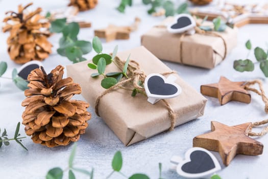 Holiday Christmas Gifts with Boxes, Coniferous, eucalyptus and ornaments on snowy background