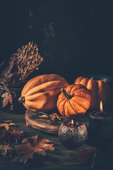 Still life for Thanksgiving with pumpkins and autumn leaves on wooden background