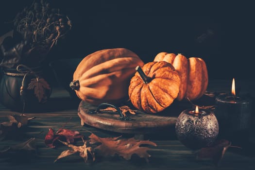 Still life for Thanksgiving with pumpkins and autumn leaves on wooden background