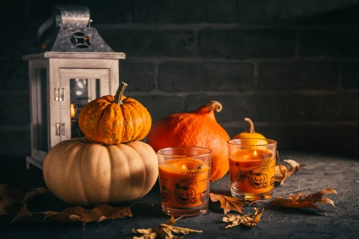 Still life for Thanksgiving with pumpkins, lantern and autumn leaves on black background