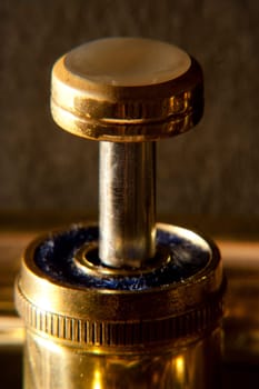 A single brass trumpet valve with differential focus