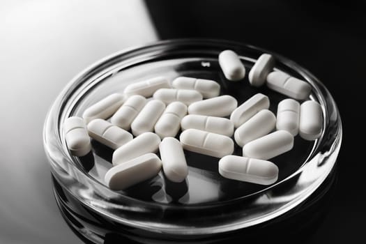 Pills in glass saucer. Pharmaceutical medicaments. Treatment concept.