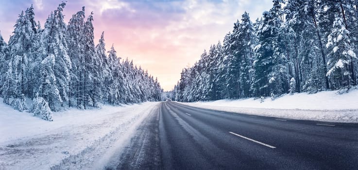 Beautiful view of the snowy curve country road in winter. Wavy way in natural park.
