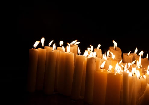 Lighted church candles in dark
