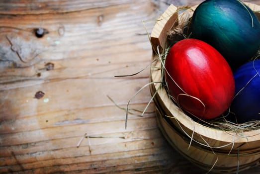 Easter eggs in wooden basket with grass