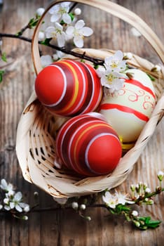 Easter eggs in basket on wooden background