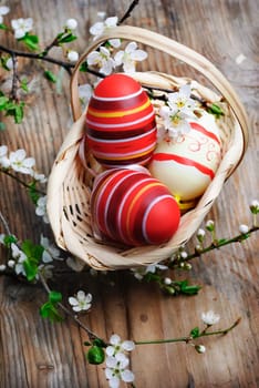 Easter eggs in basket on wooden background