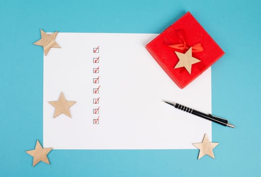 Empty paper, pen, red colored gift, stars, background for christmas, wintertime, copy space, holidays, check marks
