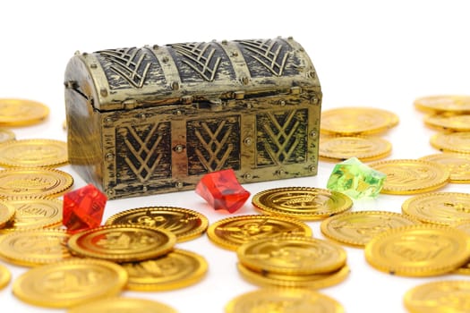 Closed treasure chest with gold colored coins on white background