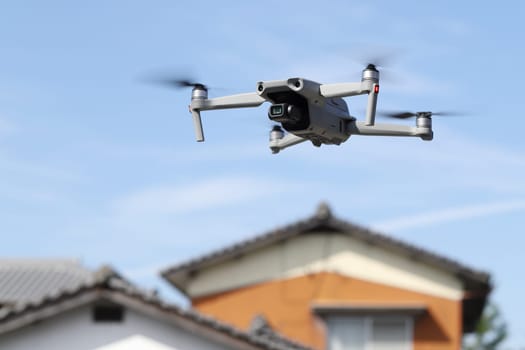 drone flying in air and blue sky with private house