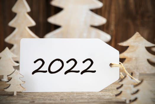 Label With Text 2022. White Wooden Christmas Tree As Decoration. Brown Wooden Background