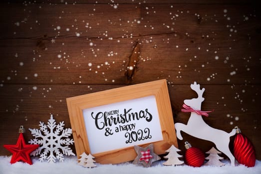 English Calligraphy Merry Christmas And Happy 2022. Red Christmas Ornament Like Tree, Ball And Wooden Deer. Wooden Background With Snow And Snowflakes