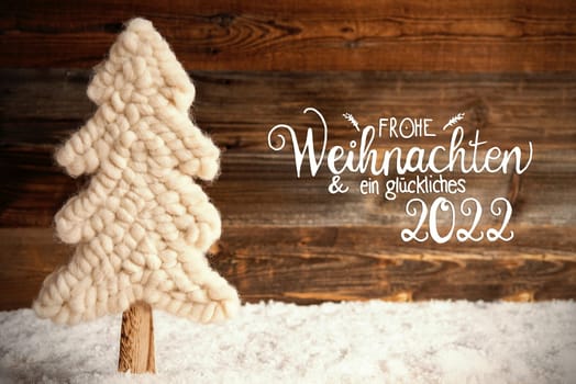 German Calligraphy Frohe Weihnachten Und Ein Glueckliches 2022 Means Merry Christmas And A Happy 2022. White Fabric Christmas Tree With Snow. Brown Rustic Wooden Background