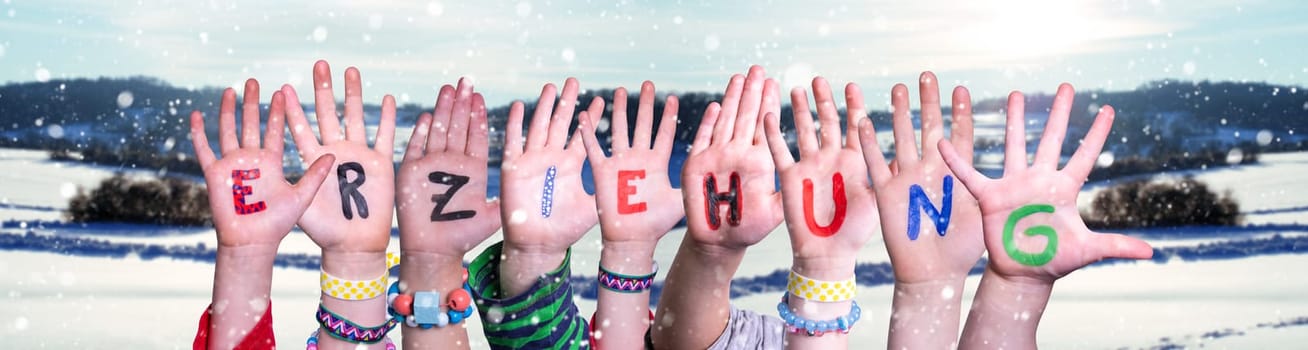 Children Hands Building Colorful German Word Erziehung Means Education. Snowy Winter Background With Snowflakes