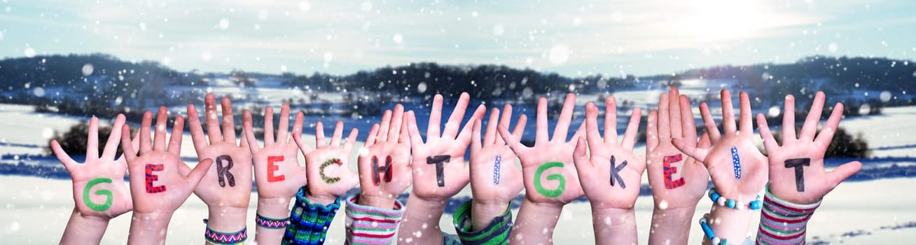 Children Hands Building Colorful German Word Gerechtigkeit Means Justice. Snowy Winter Background With Snowflakes