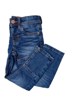 Jeans isolated. Folded trendy stylish blue denim stretch pants or trousers for child boy isolated on a white background. Clipping path. Jeans summer and autumn fashion.