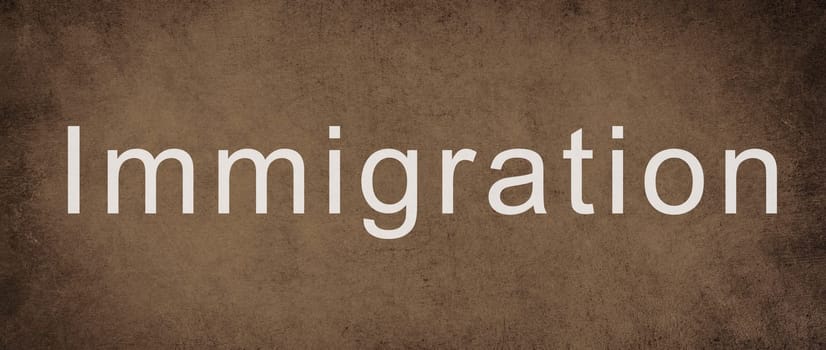 The world immigration is standing on a brown colored wall, refugees Europe, asylem seekers, immigrant