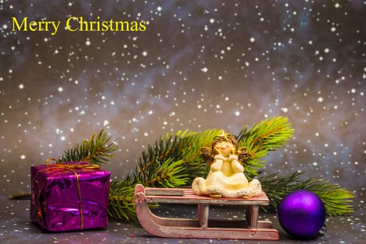 angel on sledge with night sky background and Merry Christmas text