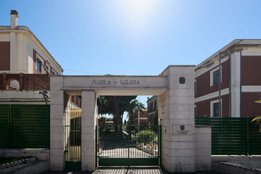 Civitavecchia. Italy - January 26, 2025: Front view of the Italian military academy in Civitavecchia, showing the gated entrance, green fence, and the main building with a clear blue sky.