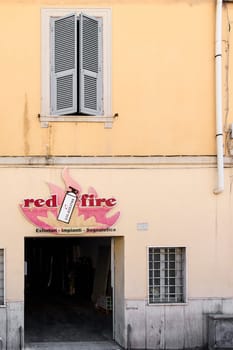 Civitavecchia, Italy - January 26, 2025: Fire safety equipment store in Civitavecchia, Italy. Yellow building facade with open window and red fire sign above the entrance. Ideal for safety issues.