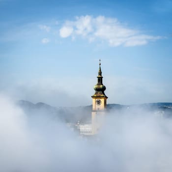 Urfahr Parish church in Linz upper Austria, view of bell tower, clock, golden sunlight, blues sky