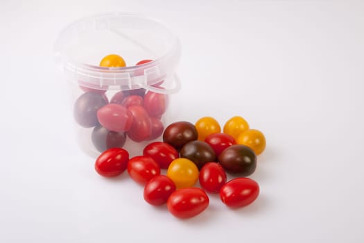 Bucket and colorful cherry tomatoes. Isolated over white background